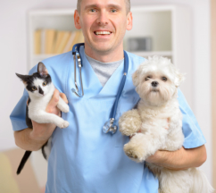 Happy vet with dog and cat, focus intentionally left on smile of veterinary
